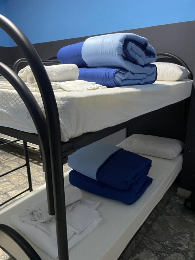 Cama individual en habitación compartida masculina, equipada con baño compartido.
